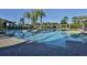 Large community pool featuring clear blue water, palm trees, and comfortable seating areas at 1386 Brayford Pt, Deland, FL 32724