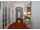 Inviting entryway with hardwood floors, decorative mirror, table, lighting, and decorative glass door at 1386 Brayford Pt, Deland, FL 32724
