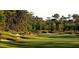 Scenic view of a lush green golf course with mature trees and sand bunkers on a sunny day at 1386 Brayford Pt, Deland, FL 32724