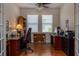 Home office with hardwood floors, two windows, ceiling fan, and custom-built shelving at 1386 Brayford Pt, Deland, FL 32724