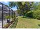 Backyard shows a screened porch surrounded by landscaped gardens at 1412 Bent Oaks Blvd, Deland, FL 32724