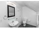 Simple bathroom featuring a pedestal sink, toilet, and a wall-mounted mirror at 1412 Bent Oaks Blvd, Deland, FL 32724