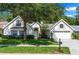 Charming single Gathering home with a large shade tree, a well-manicured lawn, and a two-car garage at 1412 Bent Oaks Blvd, Deland, FL 32724