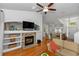 Open living room with hardwood floors, a stacked stone fireplace and built-in shelves at 1412 Bent Oaks Blvd, Deland, FL 32724
