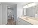Bright bathroom featuring a vanity with sink, modern lighting, and an adjacent toilet room at 1420 N Atlantic Ave # 202, Daytona Beach, FL 32118