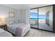 Cozy bedroom with beautiful ocean view balcony seen through a large glass door at 1420 N Atlantic Ave # 202, Daytona Beach, FL 32118