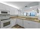 Bright kitchen features white cabinets, granite countertops, and stainless steel appliances with ocean view at 1420 N Atlantic Ave # 202, Daytona Beach, FL 32118