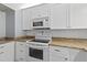 This kitchen features white appliances, ample cabinetry, and granite countertops at 1420 N Atlantic Ave # 202, Daytona Beach, FL 32118