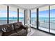 Living room with ocean views, sliding glass doors to a balcony and comfortable seating at 1420 N Atlantic Ave # 202, Daytona Beach, FL 32118