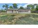 View of the home's backyard featuring a screened in lanai with an expansive lawn at 1562 Monroe St, Deland, FL 32720
