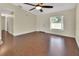 Bright living room with wood floors, ceiling fan, and natural light, with a view into the entryway at 1562 Monroe St, Deland, FL 32720