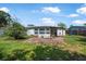 Backyard featuring a small patio and lush green lawn, perfect for outdoor activities at 1608 Raleigh Ave, Daytona Beach, FL 32117