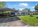 Charming single-story home with a carport, a well-manicured lawn, and blue shutters and trim at 1608 Raleigh Ave, Daytona Beach, FL 32117