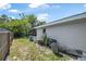 Side yard area with lush greenery and utility access, great for landscaping and storage at 1608 Raleigh Ave, Daytona Beach, FL 32117