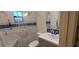 Modern bathroom with sleek fixtures, glass shower, and marble and blue tile accents at 1621 Anniston Ave, Daytona Beach, FL 32117