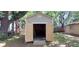 The shed has opened doors, revealing a shelving unit, and backyard trees are surrounding it at 1621 Anniston Ave, Daytona Beach, FL 32117