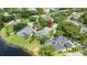 Aerial view of a home with pool, lush landscaping, and a serene lake view at 1653 Promenade Cir, Port Orange, FL 32129