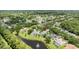 Aerial view showcases a home nestled among mature trees with a serene lake and community at 1653 Promenade Cir, Port Orange, FL 32129