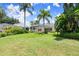 Expansive backyard featuring lush greenery and a screened-in pool area with palm trees at 1653 Promenade Cir, Port Orange, FL 32129