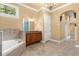 Bathroom featuring a bathtub, vanity, and arched window at 1653 Promenade Cir, Port Orange, FL 32129