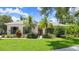 Charming home with lush landscaping, palm trees, and well-manicured lawn at 1653 Promenade Cir, Port Orange, FL 32129