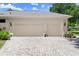 Spacious three car garage featuring a wide driveway with a paver design at 1653 Promenade Cir, Port Orange, FL 32129