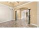 Open-concept living room with elegant chandelier, decorative columns, and neutral color palette at 1653 Promenade Cir, Port Orange, FL 32129