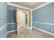 Charming home office with blue accent wall, glass paneled door, and transom window at 1653 Promenade Cir, Port Orange, FL 32129