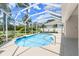A serene caged pool with lush landscaping and blue skies at 1653 Promenade Cir, Port Orange, FL 32129