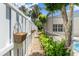 Side yard stone path with green foliage next to a white fence by the screened in pool at 1653 Promenade Cir, Port Orange, FL 32129