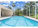 Caged pool featuring clear blue water and tropical landscaping at 1653 Promenade Cir, Port Orange, FL 32129