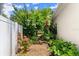Landscaped side yard with a vibrant flowerbed and garden path, shaded by lush greenery at 1653 Promenade Cir, Port Orange, FL 32129