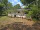 Exterior view of the home, surrounded by lush trees and a grassy backyard at 16880 Se 63Rd Ln, Ocklawaha, FL 32179