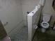 Bathroom featuring a small walk-in shower and tiled walls, in need of renovation at 16880 Se 63Rd Ln, Ocklawaha, FL 32179