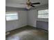 Dilapidated bedroom with a ceiling fan, floral wallpaper border, and outdated windows at 16880 Se 63Rd Ln, Ocklawaha, FL 32179