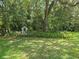 Serene backyard featuring mature trees, lush landscaping, and a charming decorative structure at 1725 Turtle Hill Rd, Enterprise, FL 32725