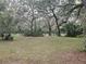 Lush backyard with mature trees and white fence, creating a serene and secluded outdoor space at 1725 Turtle Hill Rd, Enterprise, FL 32725