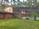 Home's backyard showing a screened-in pool, lush lawn, and partial home view at 1725 Turtle Hill Rd, Enterprise, FL 32725