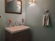 The half bathroom features a modern vanity, sink, mirror and decorative lighting at 1725 Turtle Hill Rd, Enterprise, FL 32725