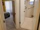 This bathroom has an open door, white tile flooring, and white tiled shower with metal handle bars at 1725 Turtle Hill Rd, Enterprise, FL 32725