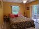 Comfortable bedroom with natural light and access to the screened patio at 1725 Turtle Hill Rd, Enterprise, FL 32725