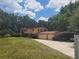 Exterior of home featuring a sprawling lawn, mature trees, a three-car garage, and a carport at 1725 Turtle Hill Rd, Enterprise, FL 32725