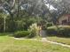 Landscaped front yard with mature trees, ornamental grasses, and a brick paver path to the home's entrance at 1725 Turtle Hill Rd, Enterprise, FL 32725