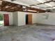 Empty garage with exposed ceiling showing beams with white cinderblock wall and concrete floor at 1725 Turtle Hill Rd, Enterprise, FL 32725