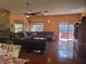 Spacious living room featuring a stone fireplace, dark wood floors, and access to a covered porch at 1725 Turtle Hill Rd, Enterprise, FL 32725