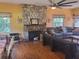 Bright living room featuring a stone fireplace, hardwood floors, and multiple windows at 1725 Turtle Hill Rd, Enterprise, FL 32725