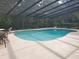 Enclosed pool area featuring a large in-ground pool, lounge chairs, and dining table with seating at 1725 Turtle Hill Rd, Enterprise, FL 32725