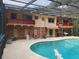 Spacious outdoor area with a pool, patio, and a two-story home with a brick exterior and balconies at 1725 Turtle Hill Rd, Enterprise, FL 32725