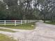 Gravel driveway leading to the property with white fencing along lush greenery at 1725 Turtle Hill Rd, Enterprise, FL 32725
