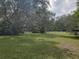 Expansive grassy yard surrounded by mature trees, framed by a white fence at 1725 Turtle Hill Rd, Enterprise, FL 32725